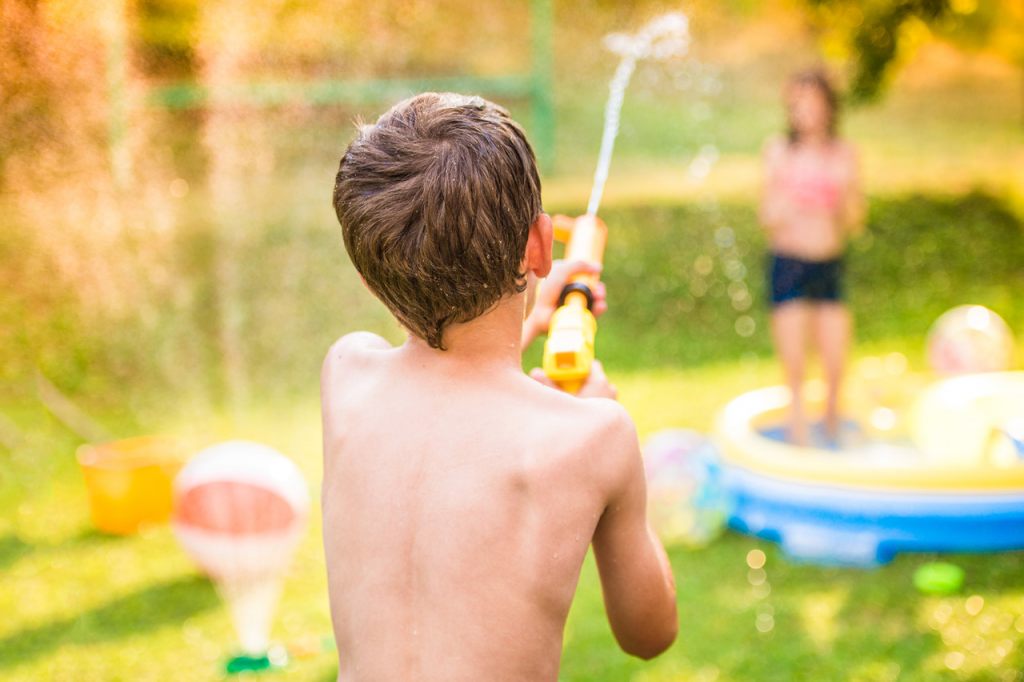 wasserpistole-wasserbomben-kinder-spielen-im-garten